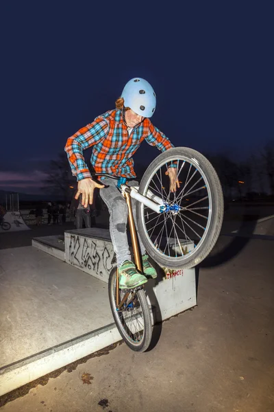 Chico salta con su dirtbike en el parque de skate sobre una rampa —  Fotos de Stock