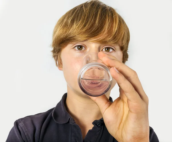 Boy drinks water out of a glass — Stock Photo, Image