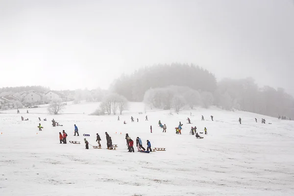 Les enfants patinent à une piste de luge en hiver — Photo