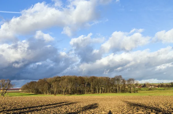 Landdistrikterne landskab med pløjet marker og blå himmel - Stock-foto