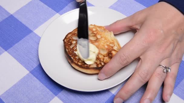 食堂の女性はそれを食べる前に彼女の新鮮なトースト英語マフィンにバターを広げます — ストック動画