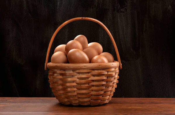 Ένα Ψάθινο Καλάθι Φρεσκοσυλλεχθέντα Καφέ Αυγά Πάνω Από Ένα Ξύλινο — Φωτογραφία Αρχείου