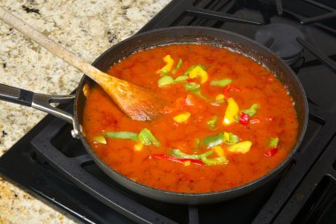 Simmering marinara sauce and vegetables clipart