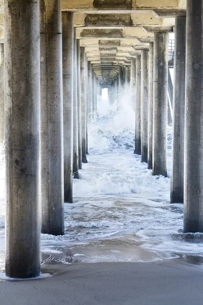 Ruwe water bij strand onder pier — Stockfoto