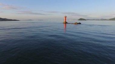 Deniz feneri ile üzerinde uçan uçak