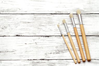 Beyaz grunge ahşap masa üzerinde boya fırçaları