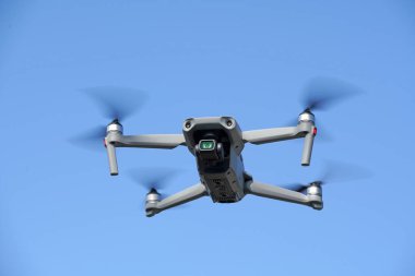              Havada uçan İHA ve açık mavi gökyüzü arkaplanı   