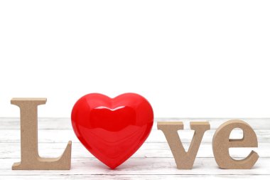 Kırmızı kalp süslemesi yaşlanmış beyaz ahşap bir masada 