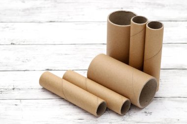 Beyaz ahşap bir masanın üzerindeki karton silindirler.   