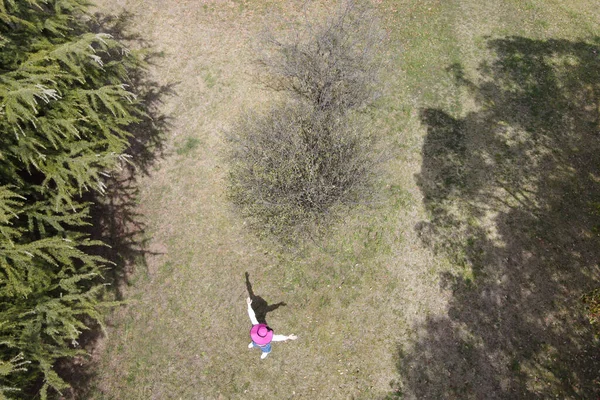 一个戴着粉色帽子的女人在森林里从无人机上射击暑假 — 图库照片
