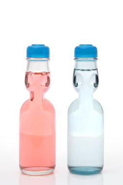 Soda beyaz arka planda bir şişede Ramune içer.