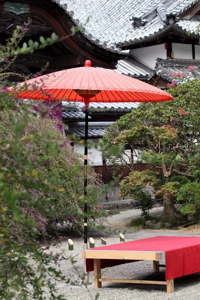 Red umbrella in garden — Stock Photo, Image