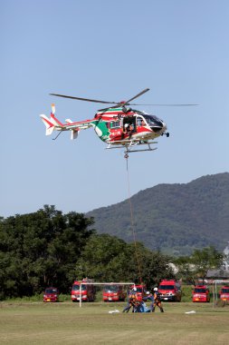 İtfaiyeci bir helikopter ile çalışır