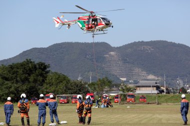 İtfaiyeci bir helikopter ile çalışır