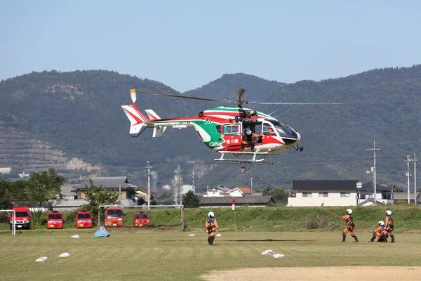 İtfaiyeci bir helikopter ile çalışır