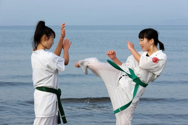 Japonés karate niñas entrenamiento en la playa —  Fotos de Stock