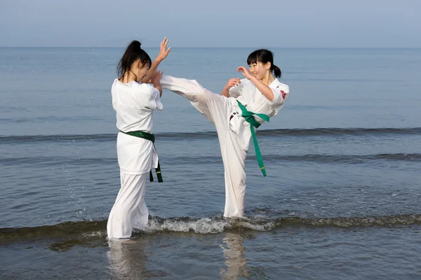 Japonés karate niñas entrenamiento en la playa —  Fotos de Stock