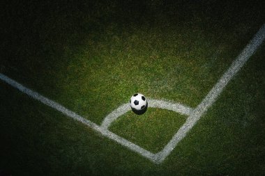 Futbol stadyumunun köşesindeki yeşil çimlerin üzerinde bir futbol topu. köşe tekme.