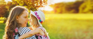 Güzel gülümseyen kız annesiyle dışarıda dinleniyor.