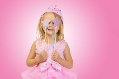 Uzun saçlı, tül etekli, elinde büyücüyle neşeli küçük kız.