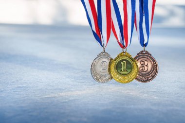 golden medal on the textured ice surface in the snow - winter sport successful concept