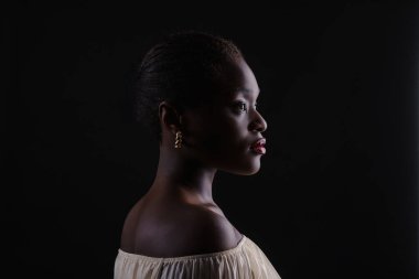 Afro-Amerikalı bir kadın bu anın tadını çıkarıyor. Hassas an koyu arkaplanda yalıtılmış.