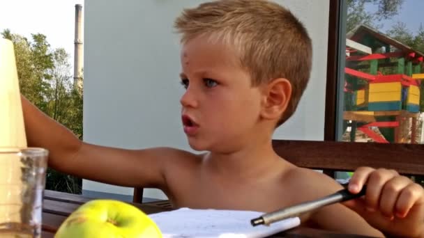 Little boy doing homework, camera panning — Stock Video