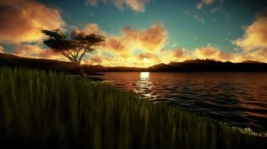 Yeşil çayır ve dağlarla çevrili Gölü üzerinde güzel gün batımı