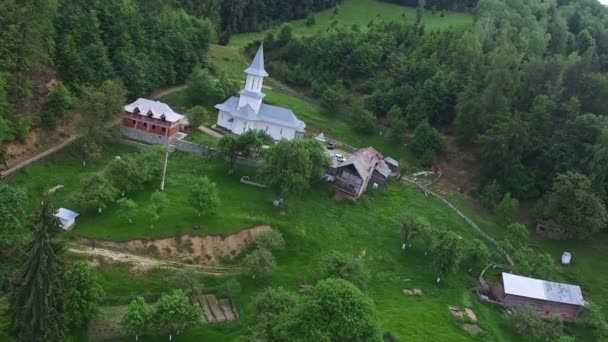 Église chrétienne au sommet de la colline verdoyante entourée de forêt, vol aérien — Video