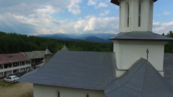 Християнська Церква на вершині зеленого пагорба з гірського хребта, cam літати — стокове відео