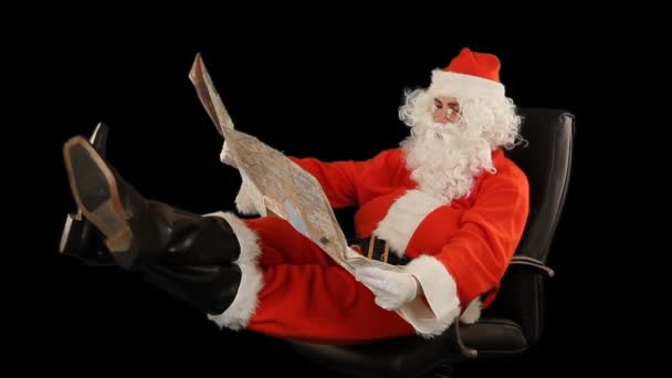 Άγιος Βασίλης Κάθεται Μια Δερμάτινη Καρέκλα Και Κοιτάζοντας Ένα Χάρτη — Αρχείο Βίντεο