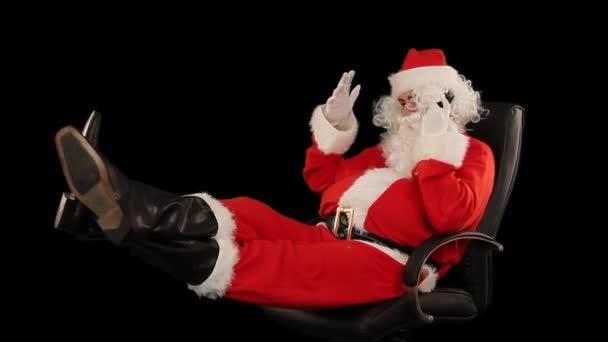 Санта Клаус Сидить Шкіряному Стільці Розмовляє Мобільному Телефону Альфа Канал — стокове відео