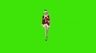 Noel kıyafetli güzel bir kadın kameraya doğru yürüyor, dönüyor, Yeşil Ekran Chromakey