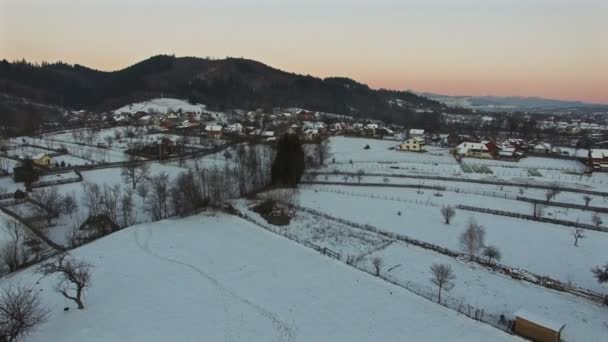 Luchtfoto vlucht over besneeuwde dorp, camera aflopend — Stockvideo