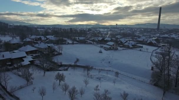 日没での田舎の村の上を飛んでの冬景色 — ストック動画