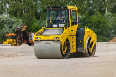 TOGLIATTI, RUSSIA - 21 Temmuz 2008: Karayolu araçları yeni asfalt döşemede çalışır. Yol kenarındaki inşaatı asfaltlamak için özel yol makineleri. Yol yapımı ve onarımı