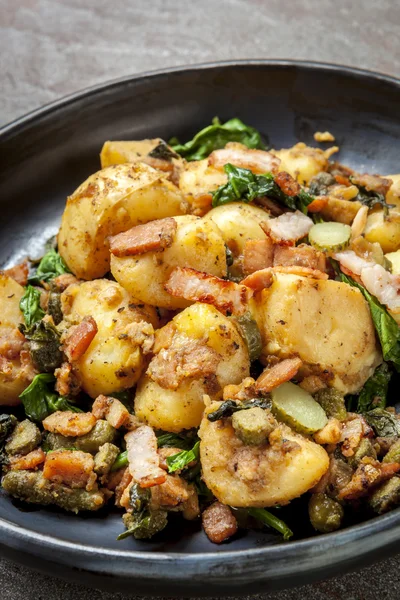 Kartoffel-Spinat-Hasch mit Cornichons und Speck — Stockfoto
