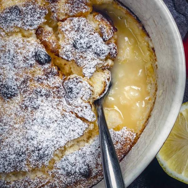 Pudding Cytrynowy Widok Góry Naczyniu Pieczenia Łyżeczką Pyszny Deser Samoprzylepny — Zdjęcie stockowe