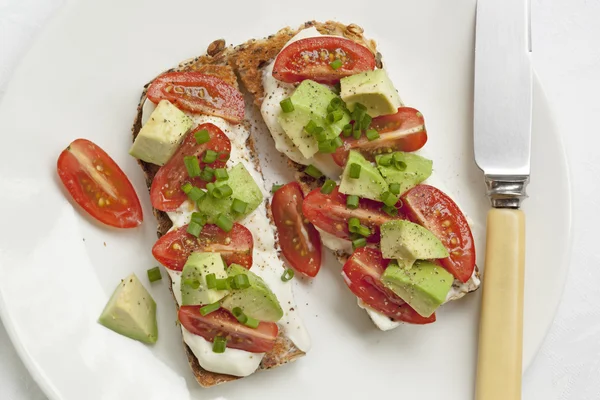 Tostadas con tomates de aguacate y queso crema —  Fotos de Stock