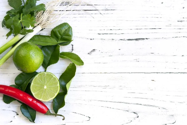 Lebensmittel Hintergrund mit Limetten Koriander, rotem Chili und Frühlingszwiebeln — Stockfoto