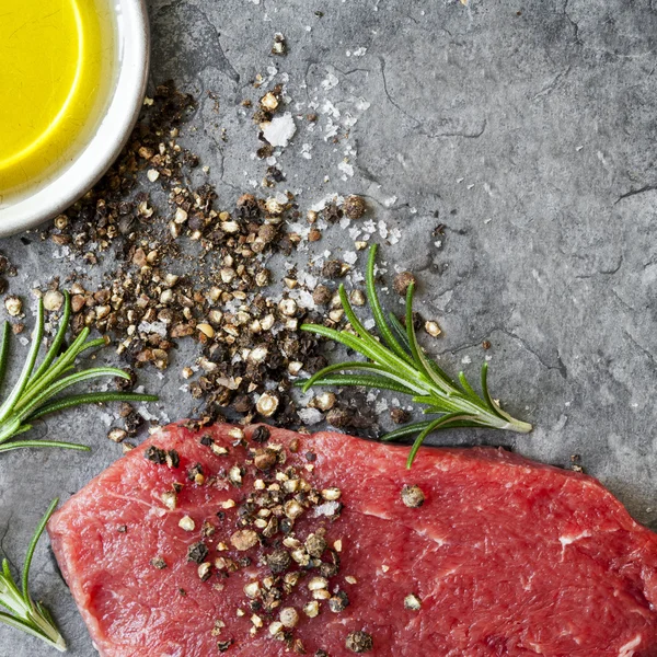 Syrové hovězí Steak s Sea pepřem sůl olivový olej a rozmarýnem — Stock fotografie
