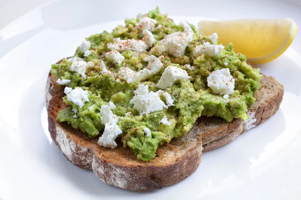 Toast all'avocado con formaggio feta limone e spezie — Foto Stock