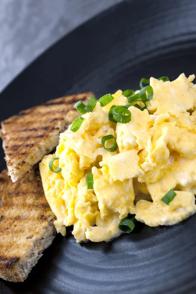 Scrambled Eggs with Toast on Black Plate — Stock Photo, Image