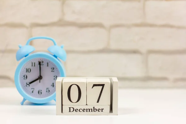 Δεκεμβρίου Ένα Ξύλινο Ημερολόγιο Δίπλα Στο Ξυπνητήρι Ένα Φωτεινό Τραπέζι — Φωτογραφία Αρχείου