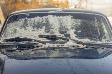 Arabanın ön camı kışın ilk günlerinde kar ve buzla kaplıydı..