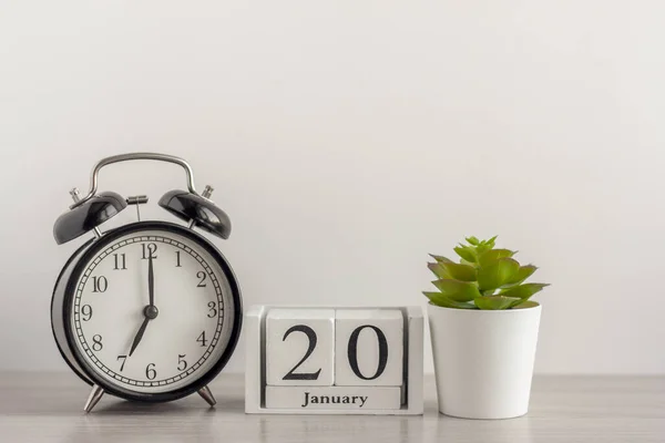 20 Ιανουαρίου σε ένα ξύλινο ημερολόγιο, δίπλα σε ένα ρετρό ξυπνητήρι και ένα χυμώδες σε μια μικρή κατσαρόλα σε ένα ελαφρύ τραπέζι.Μια μέρα τον Ιανουάριο. Χειμερινή ημέρα.Ένα αντίγραφο του χώρου.Χώρος εργασίας. — Φωτογραφία Αρχείου