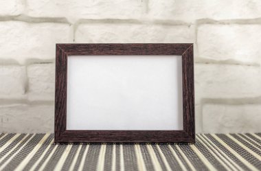 Empty photo frame in a dark frame on a table or shelf with a copy of the place.