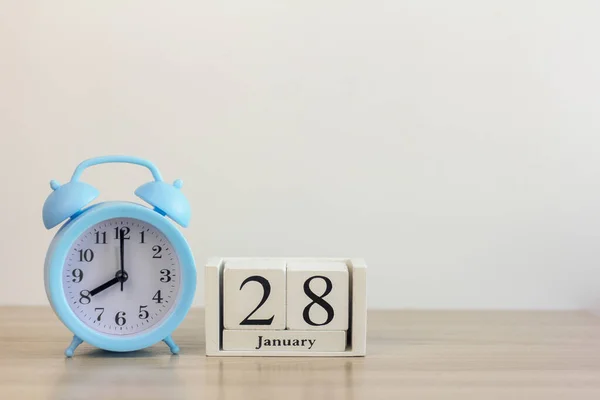 28 gennaio su un calendario bianco, accanto a una sveglia retrò su uno sfondo chiaro.Calendario per gennaio.. — Foto Stock