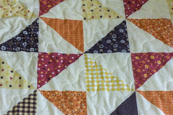 Quilt. A fragment of a patchwork quilt as a background. Colored patchwork quilt.