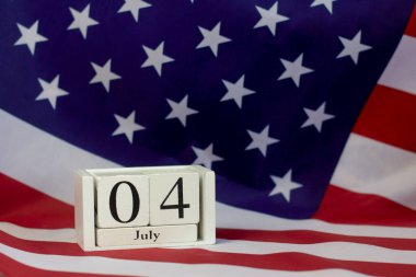 Amerikan bayrağının arka planındaki takvimde 4 Temmuz. ABD Bağımsızlık Günü